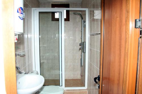 a bathroom with a shower and a toilet and a sink at Interrum Hotel in Razgrad