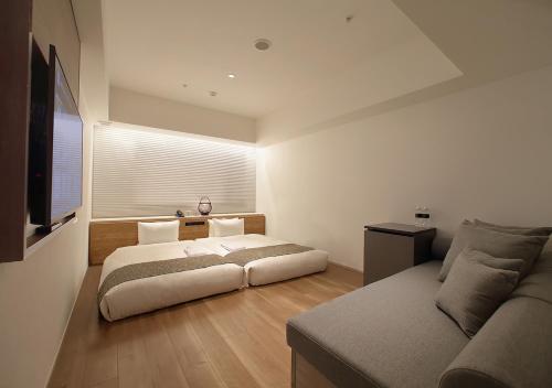 a bedroom with a large bed and a couch at ORIENTAL HOTEL KYOTO ROKUJO in Kyoto