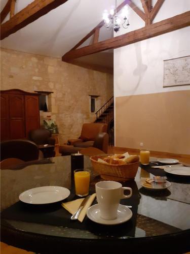 einen Tisch mit einer Tasse Kaffee und einer Schüssel Essen in der Unterkunft Domaine du chauvet in Sainte-Eulalie