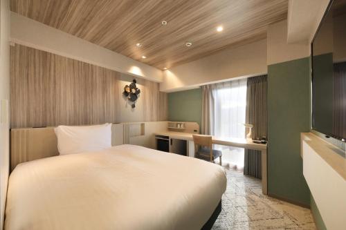 a hotel room with a bed and a desk at Richmond Hotel Morioka Ekimae in Morioka