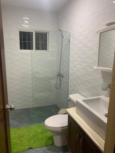 a bathroom with a shower and a toilet and a sink at Cozy 2br-2bt Apt Near The Beach And Main Street in Sosúa
