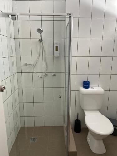 a bathroom with a shower with a toilet and a glass door at Warrina Motor Inn Wodonga CBD in Wodonga