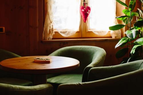 a table and two chairs and a table with a pizza on it at Hotel Natale in Cortina dʼAmpezzo