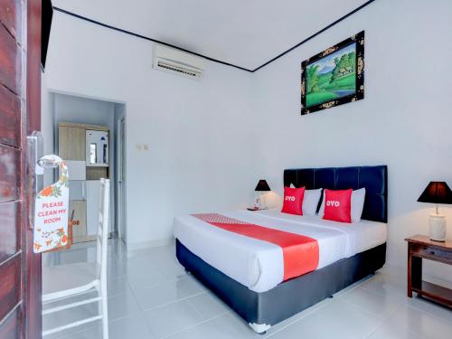 a bedroom with a bed and a tv on the wall at Bahtera Guest House in Denpasar