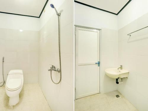 a bathroom with a shower and a toilet and a sink at Bahtera Guest House in Denpasar