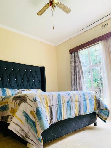 a bedroom with a bed and a ceiling fan at SapzRes at Klerksdorp in Klerksdorp