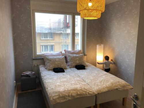 a child standing next to a bed in a bedroom at Perheasunto keskustassa in Tampere