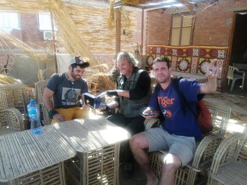a group of three men sitting at a table at david hostel in Aswan