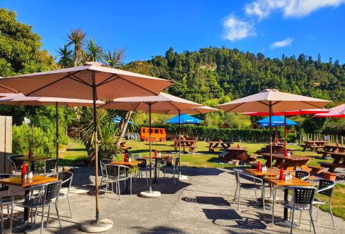 a group of tables and chairs with umbrellas at Flat Hills Tourist Park in Ruahine