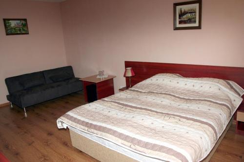 a bedroom with a large bed and a couch at Interrum Hotel in Razgrad