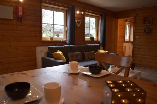a living room with a wooden table and a couch at Gîte du cheval blanc in Sainte-Ode