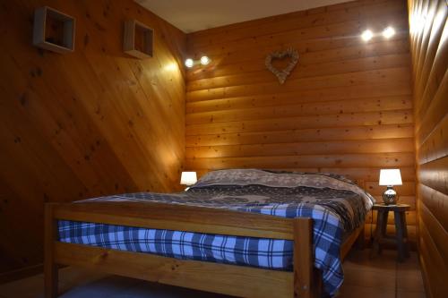 Gîte du cheval blanc في سينت اوده: غرفة نوم بسرير في غرفة خشبية