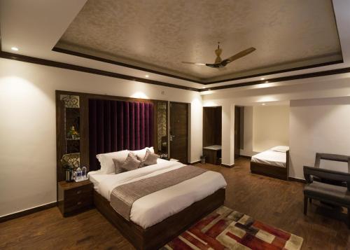a hotel room with two beds and a chair at The Highland Park - A Truly River side Resort in Manāli