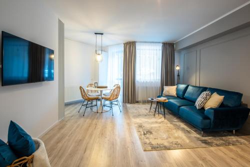 un salon avec un canapé bleu et une table dans l'établissement Snowdrop Apartment, à Sinaia