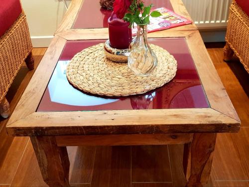 a wooden coffee table with a vase on top of it at Gästehaus am Kattensteert in Borchel