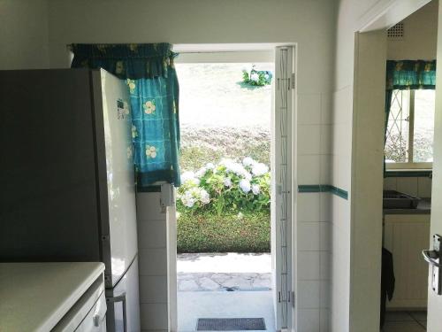 a kitchen with a door open to a garden at BillsBest Beach House in Margate