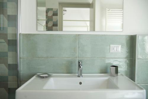 un lavandino bianco in un bagno con specchio di Il Gelsomino a Roseto degli Abruzzi