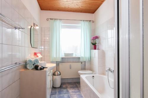 y baño con bañera, aseo y lavamanos. en Ferienwohnung Hartwimmer - Chiemgau Karte, en Inzell