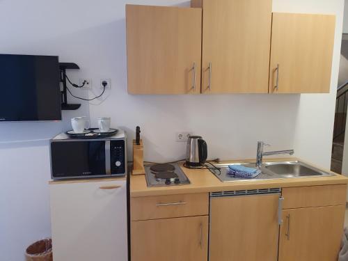 a small kitchen with a microwave and a sink at Gästehaus Altstadttraum in Leer