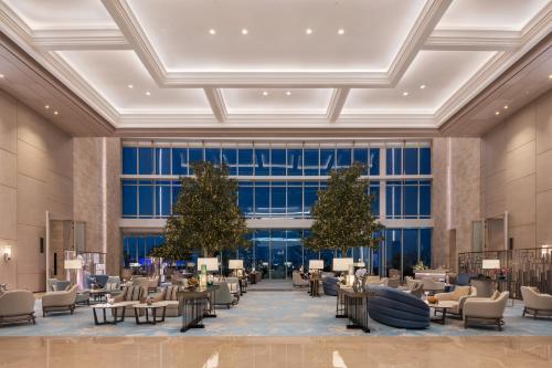 a rendering of a lobby with chairs and trees at Address Beach Resort in Dubai