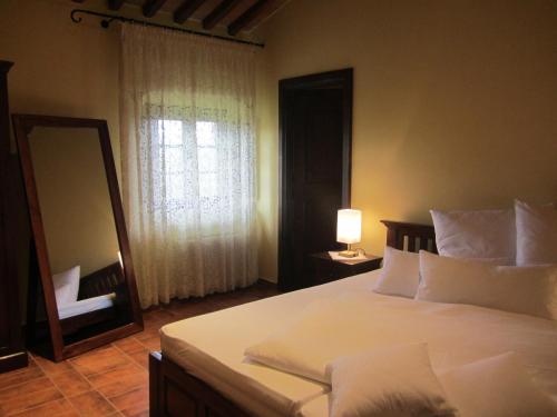 a bedroom with a bed with a mirror and a dresser at Tenuta Seripa in Sassetta