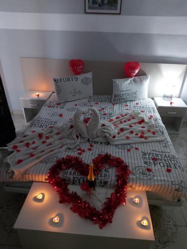 a bedroom with two beds with a heart made of roses at Pensiunea B&B Casa Italia in Timişoara