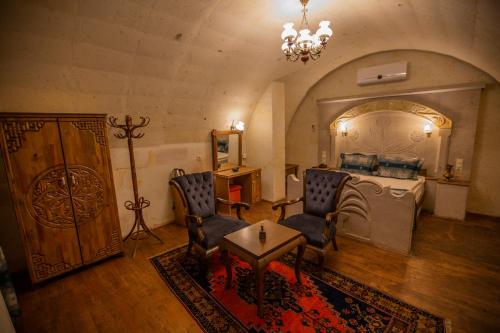 a living room with chairs and a table and a bed at Göreme Reva Hotel in Goreme