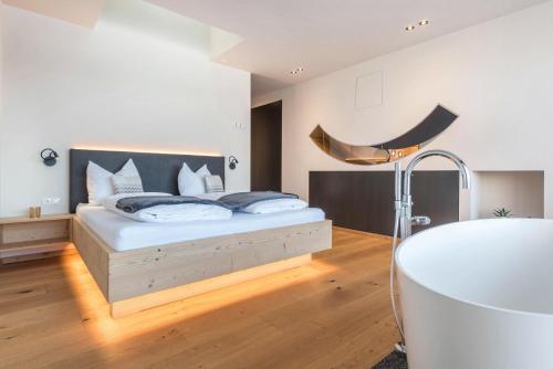a bedroom with a bed and a tub in it at Aura Chalets - Nr 3 in Castelrotto