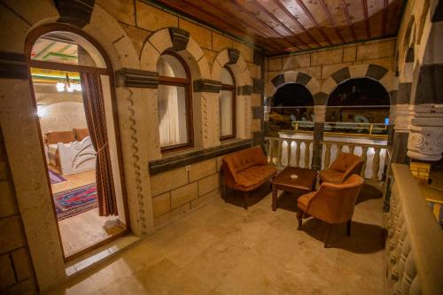 a room with two chairs and a table and windows at Göreme Reva Hotel in Goreme