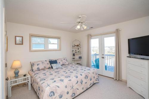 um quarto com uma cama e uma televisão de ecrã plano em Shore 'Nuff em Oak Island