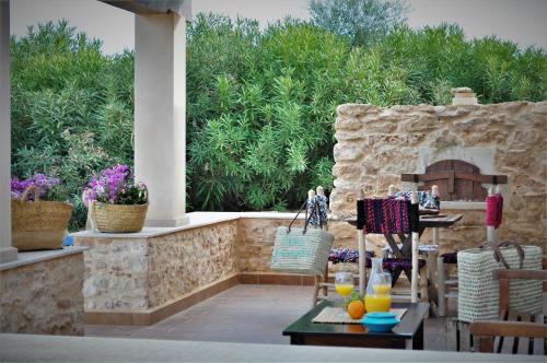 patio con mesa y chimenea de piedra en Siamoformentera Villa Annabella, en Sant Francesc Xavier