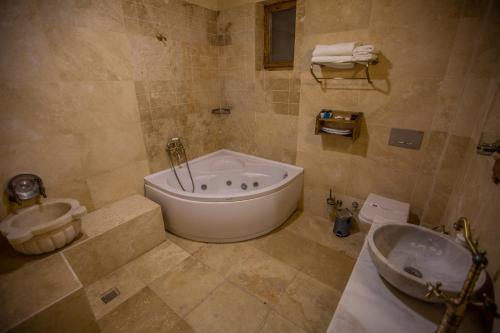 a large bathroom with a tub and a sink at Göreme Reva Hotel in Goreme