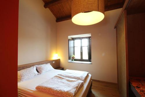 a bedroom with a bed and a window at Agriturismo Tetto Garrone in Cuneo