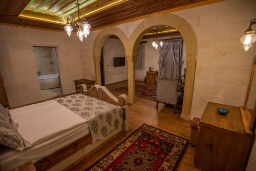 a bedroom with a bed and a bathroom with a tub at Göreme Reva Hotel in Goreme