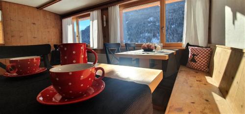 a room with two red cups and a table with a view at B&B Piz d'Err in Tinzen