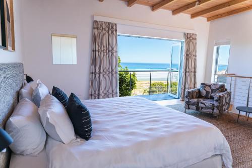 a bedroom with a large bed with a view of the ocean at Cape Beach Villa in Noordhoek