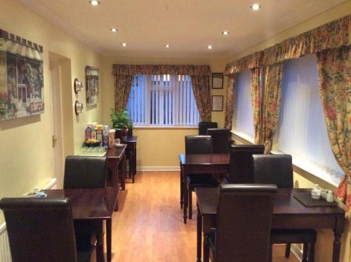 a dining room with tables and chairs and a window at White Lodge Guest House in Skegness