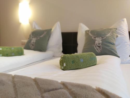 two beds with pillows and a green pillow on them at Appartements Sportsüberl in Berwang