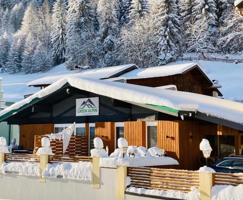 a building with snow covered people in front of it at Apartment Olperer in Mühlbachl
