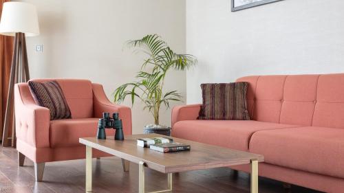 a living room with two pink couches and a coffee table at Emara Ole-Sereni in Nairobi