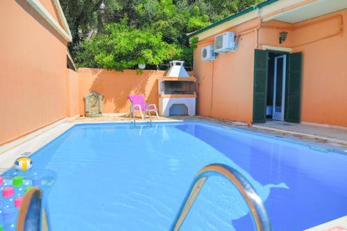 a swimming pool with two chairs and a house at Mare Vista Ariadni in Nisakion