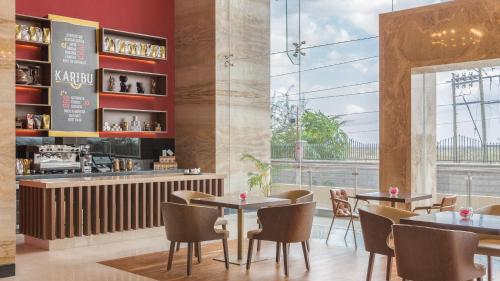 a restaurant with tables and chairs and a bar at Emara Ole-Sereni in Nairobi