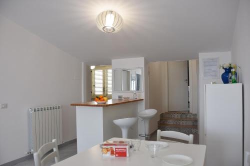 uma cozinha com uma mesa e cadeiras e um frigorífico em Ionio Sea Apartment em Marina di Gioiosa Ionica