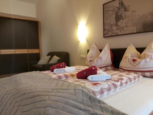 a bed with red and white pillows on it at Appartements Sportsüberl in Berwang