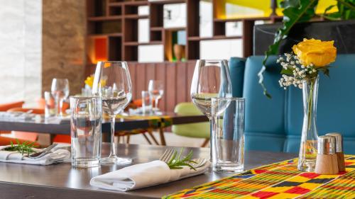 a table with wine glasses and a vase with flowers at Emara Ole-Sereni in Nairobi