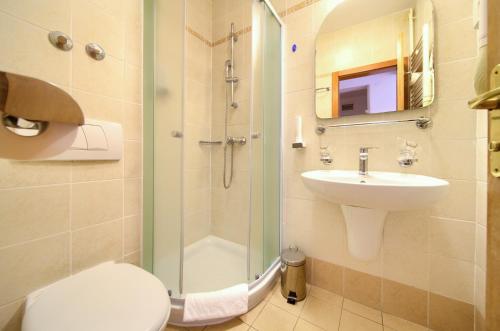 a bathroom with a shower and a toilet and a sink at Villa Lovorka - Hotel Resort Dražica in Krk