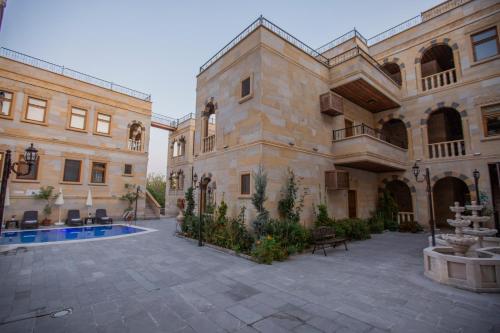 a large building with a courtyard with a fountain at Göreme Reva Hotel in Goreme