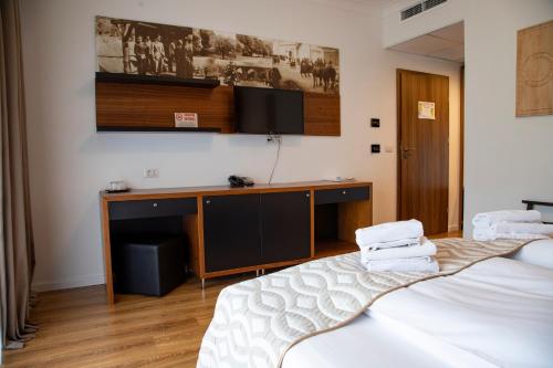 a room with two beds and a desk with a tv at Mirage Resort & Spa in Vişeu de Sus