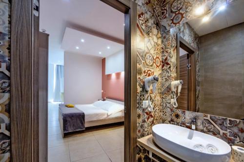 a bathroom with a tub, sink and mirror at San Giorgio Palace Hotel Ragusa Ibla in Ragusa