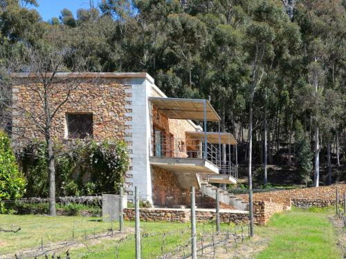 a brick house with stairs in front of trees at La Roche Estate in Franschhoek